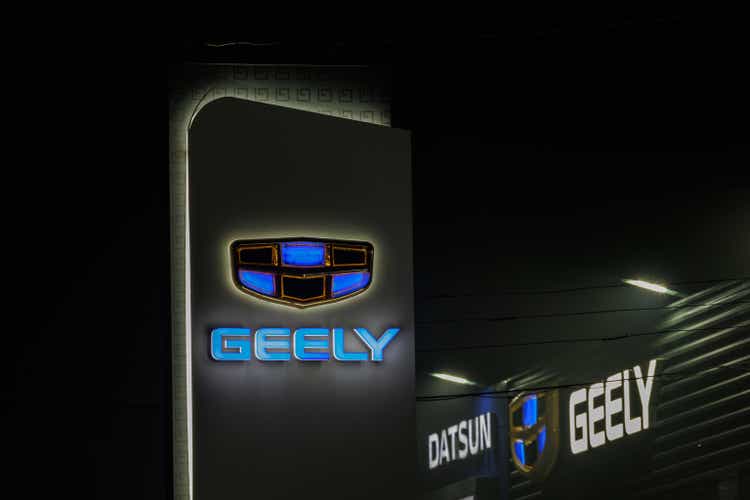 Geely logo on car dealership pillar and building at foggy night - Geely is one of the largest Chinese automobile manufacturer